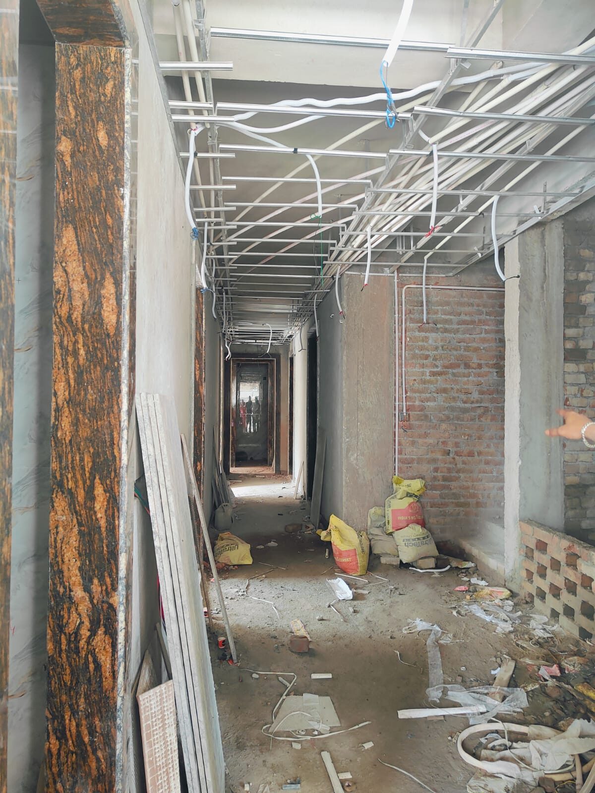 Finished hotel corridor with wainscoting, patterned flooring and pendant lights