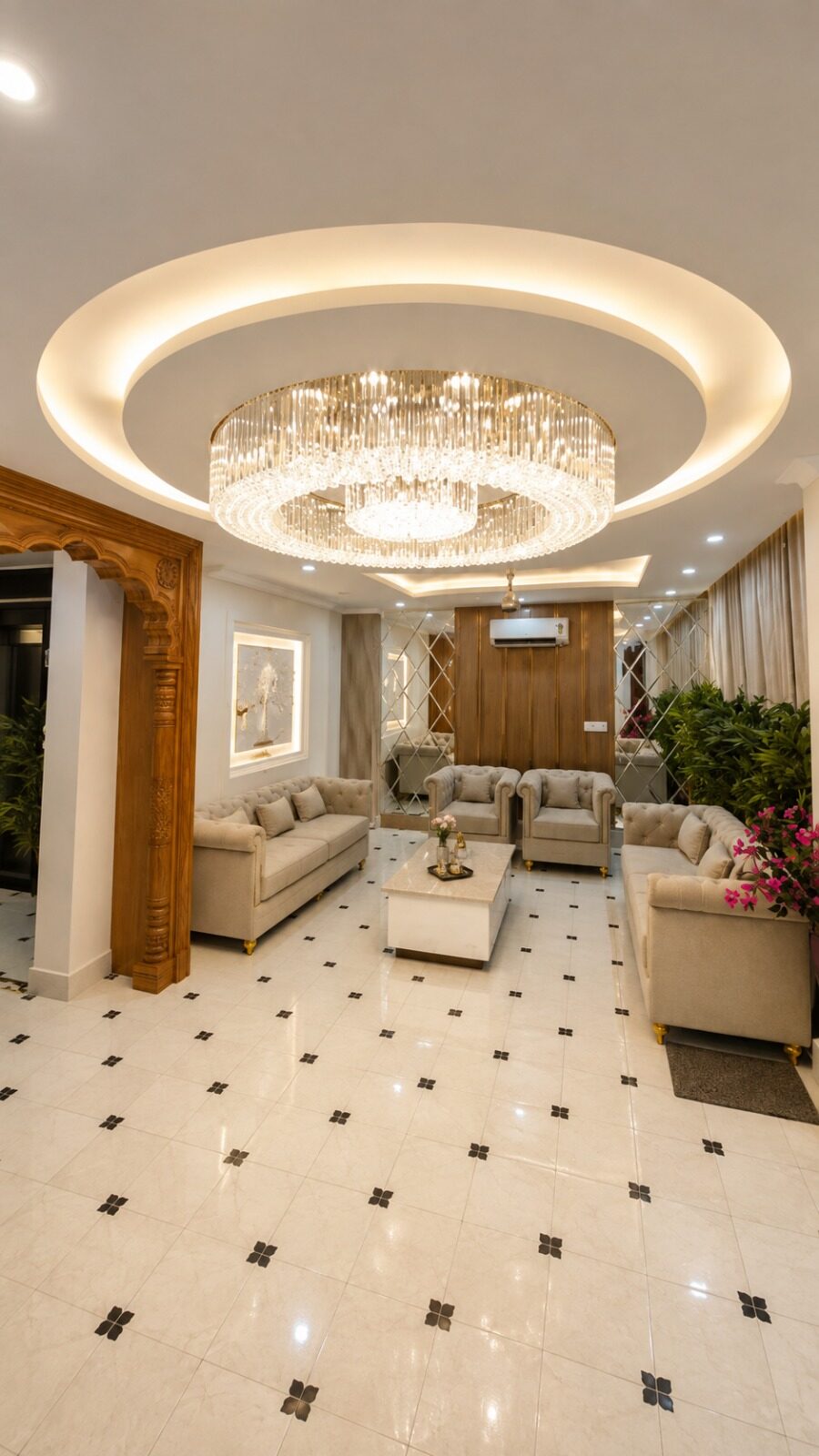 Finished living room with a circular crystal chandelier and beige upholstered sofas