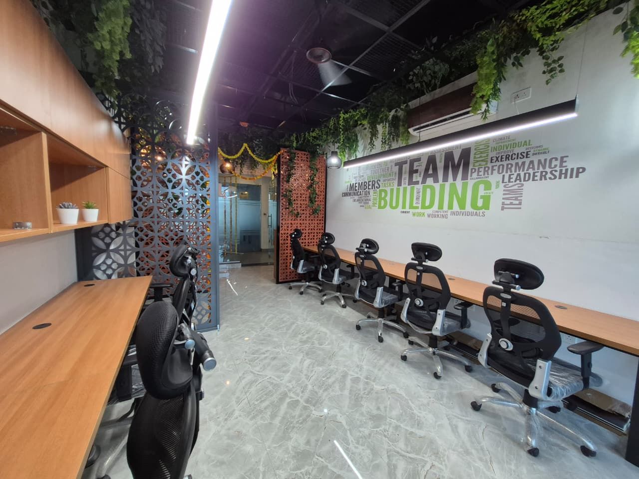 Linear working desks with task chairs and overhead lighting