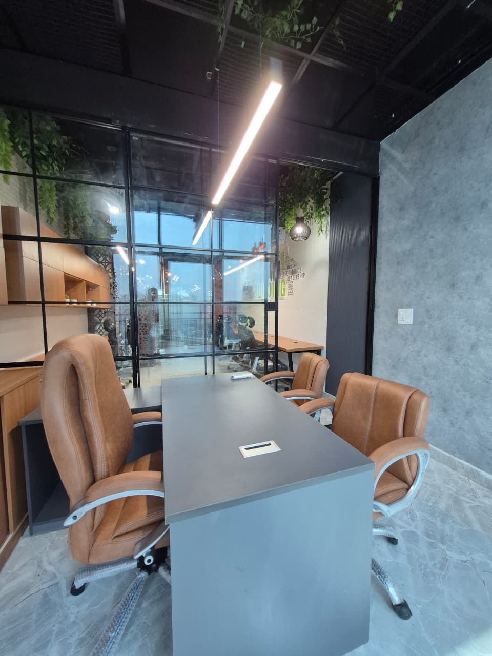 Open-plan office with linear workstation banks and a green feature ceiling