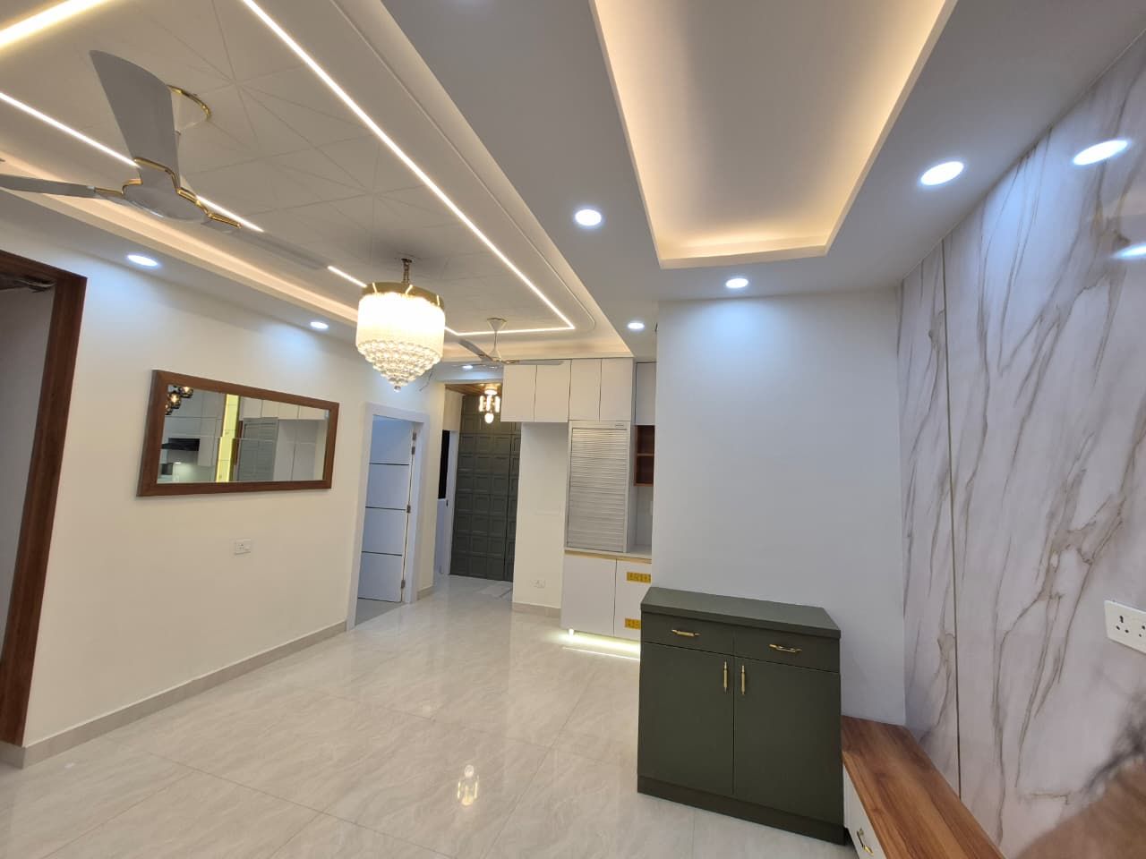 Corridor with mirror panel, cove lighting and marble flooring