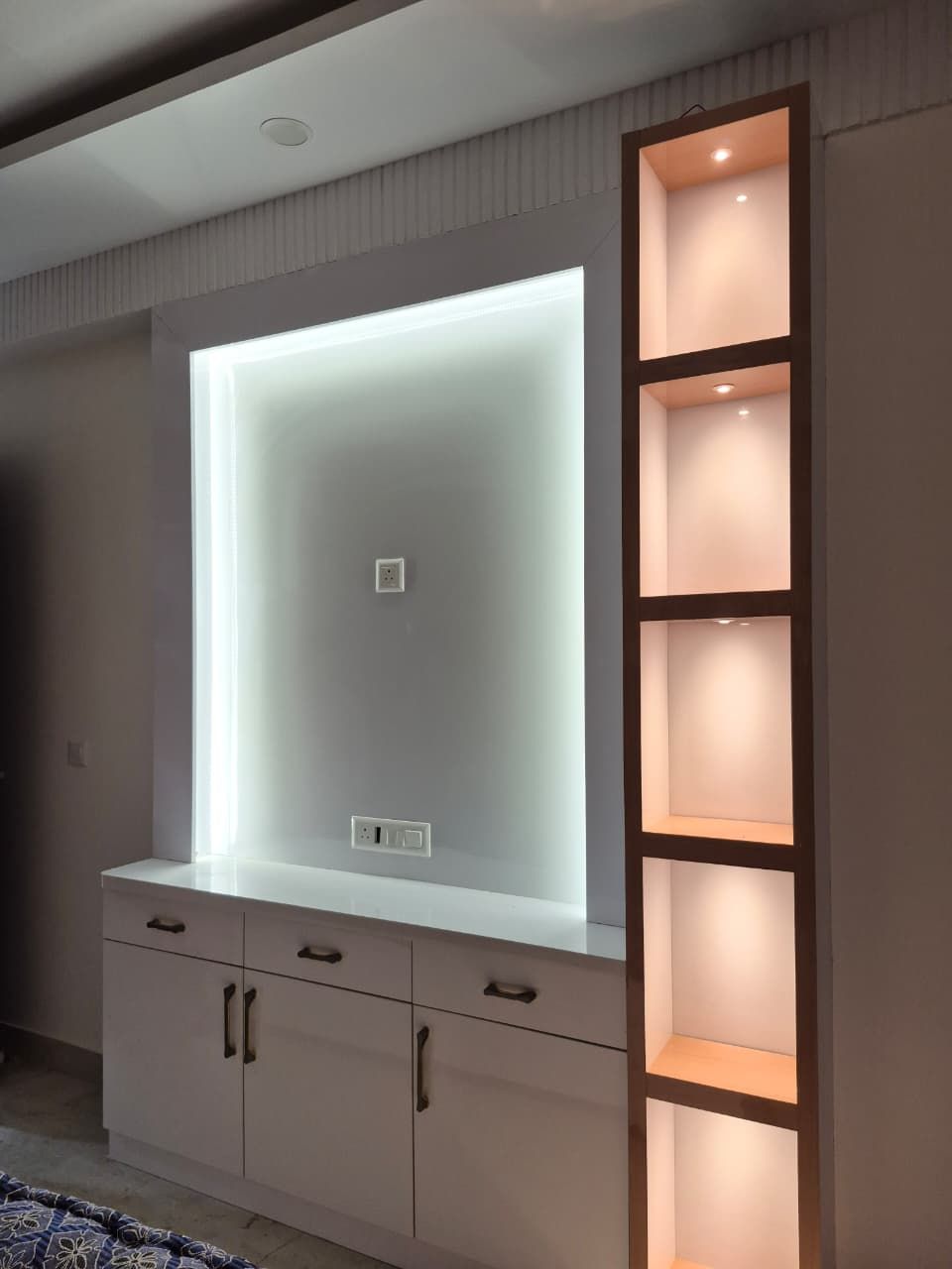 Backlit crockery display niche with open shelving and drawer storage
