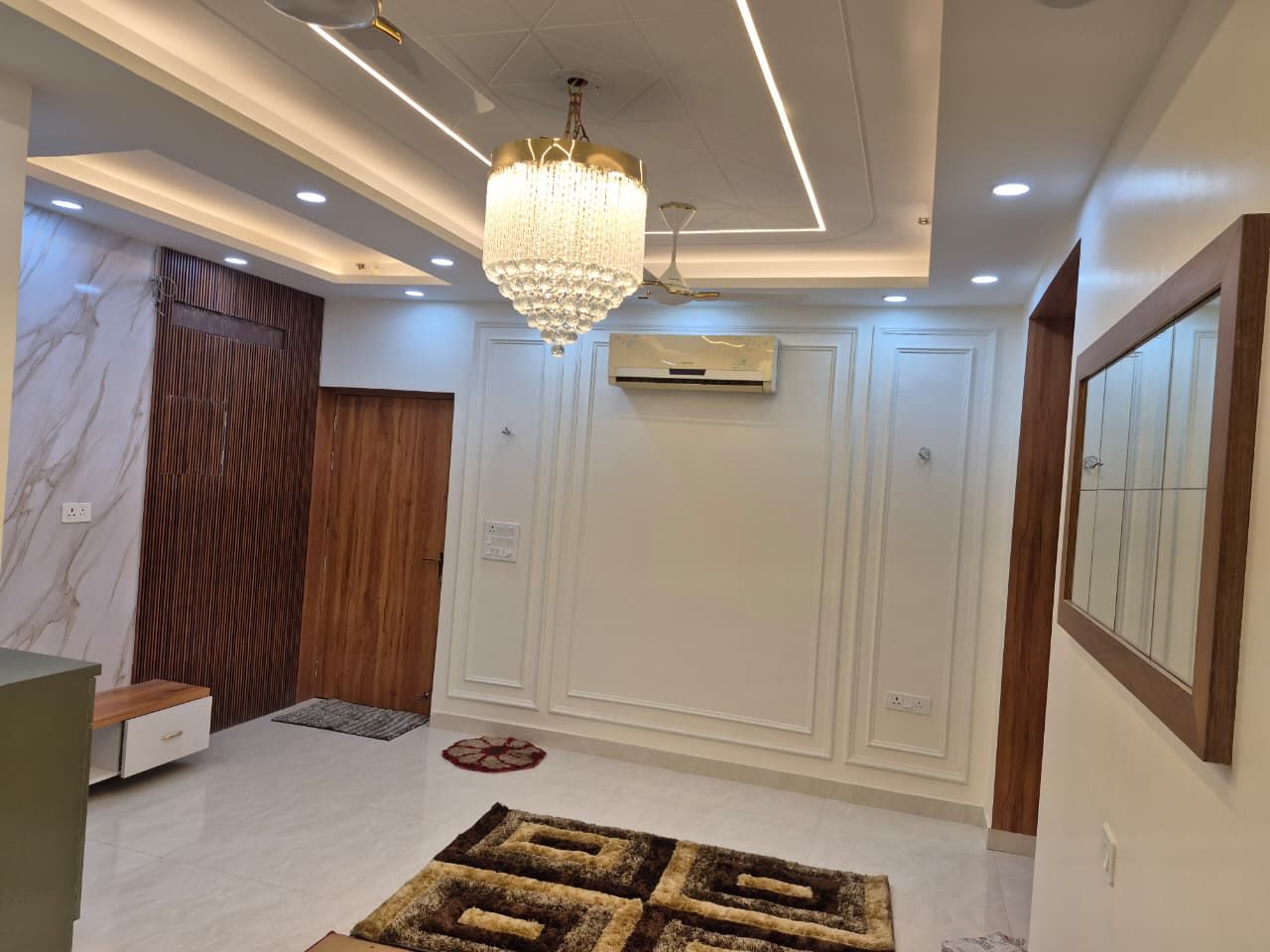 Layered false ceiling with cove lighting above the entrance lobby
